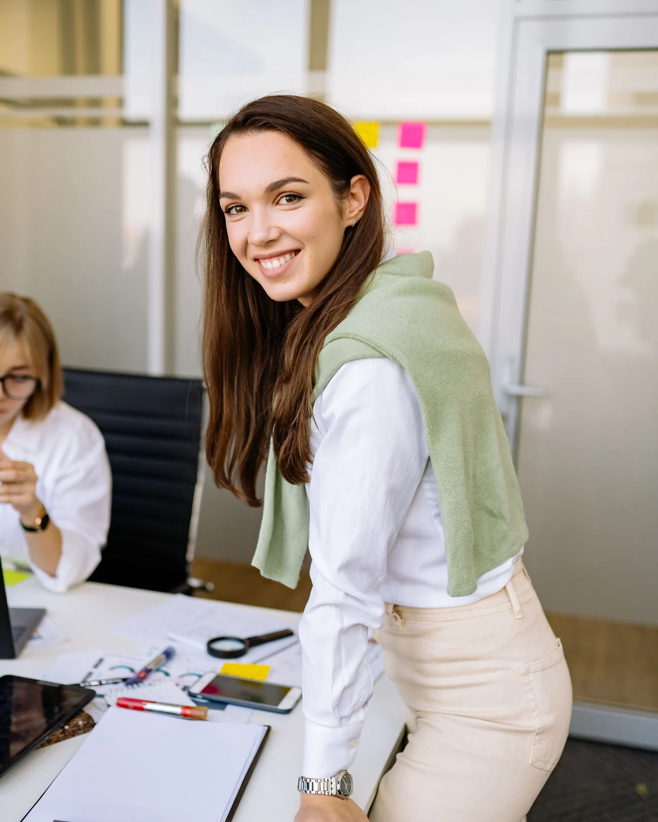 Lächelnde Mitarbeiterin am Schreibtisch im Büro