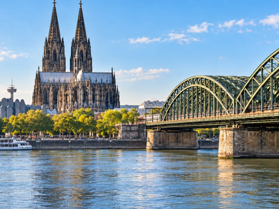 KI-generierte Illustration: Kölner Dom und Hohenzollernbrücke über dem Rhein.